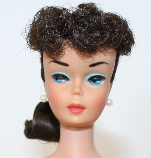 the face of 1960s brunette Barbie with averted eyes